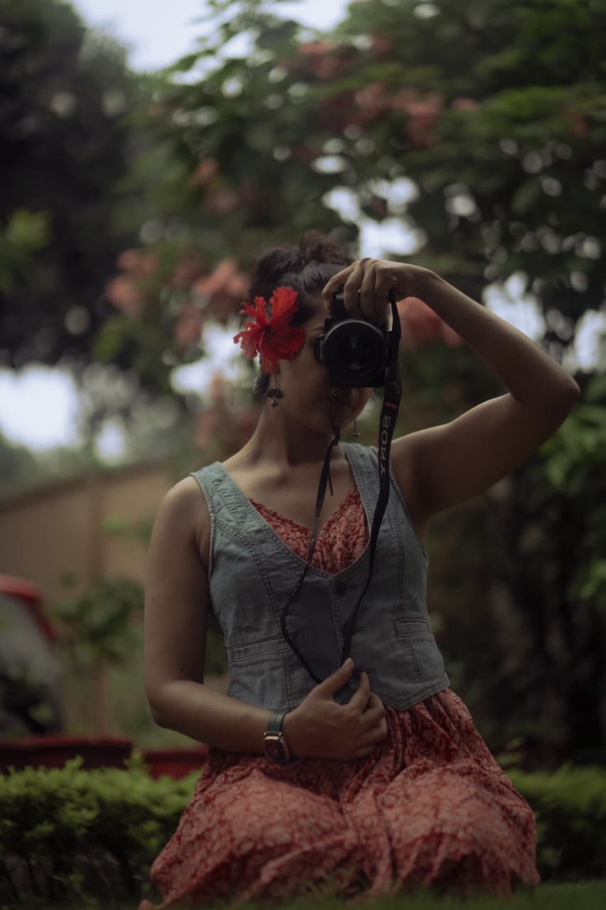 Sanskriti Bhagat holding a camera, taking a self-portrait outdoors